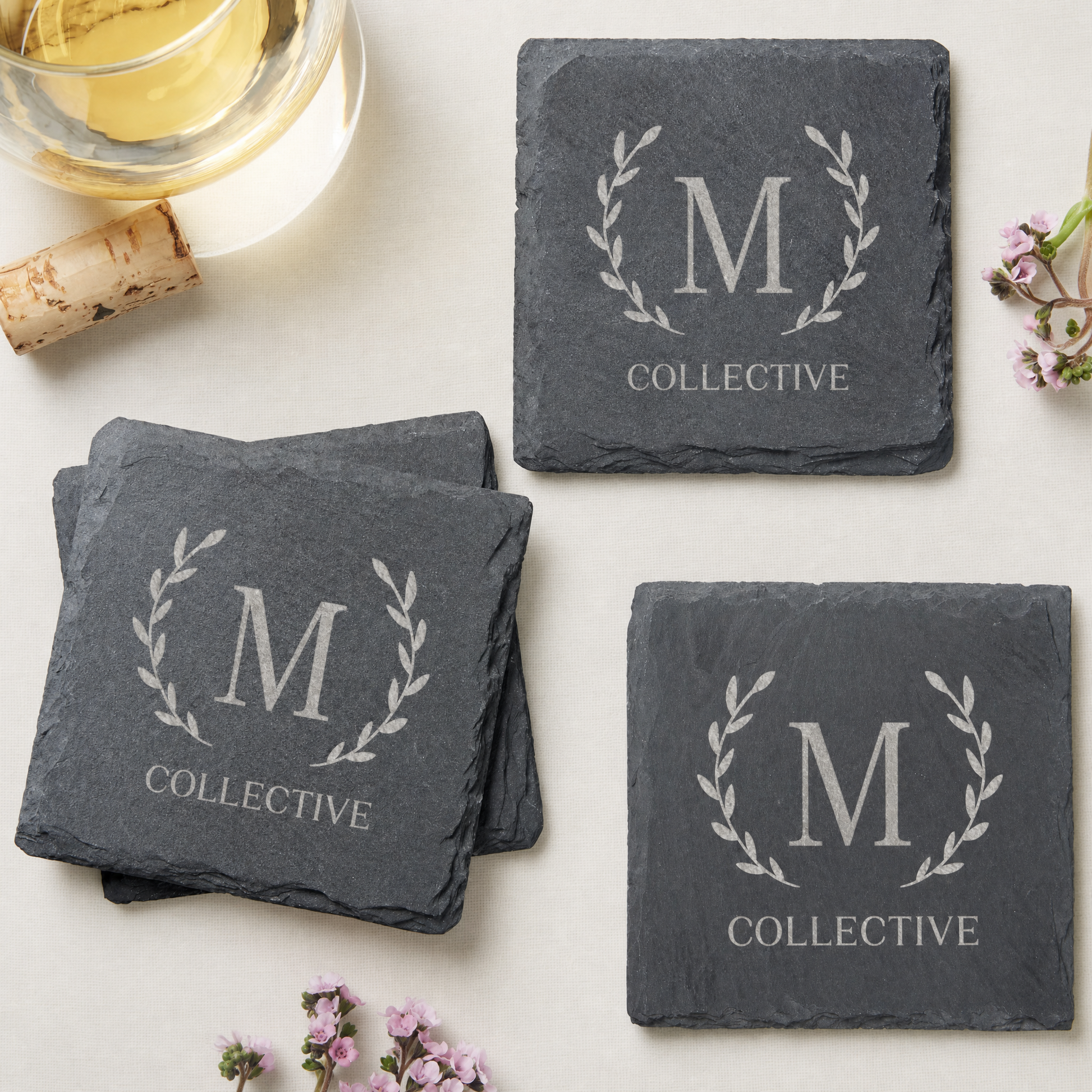 Personalized monogram slate coaster set engraved with "M" and "COLLECTIVE" on a light background